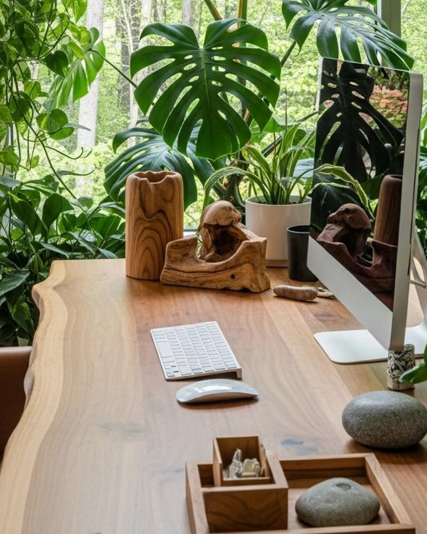 Ambiente criativo com mesa de madeira, computador e plantas